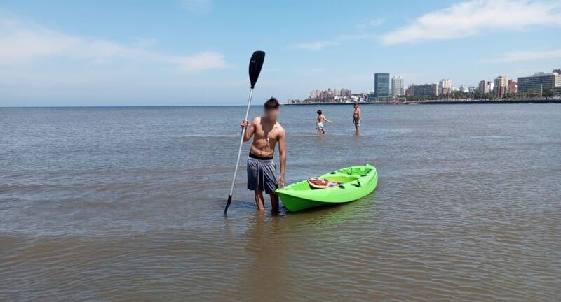 Joven en el agua con una canoa