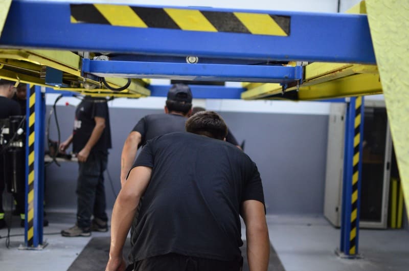 Jóvenes debajo de una plataforma automotriz