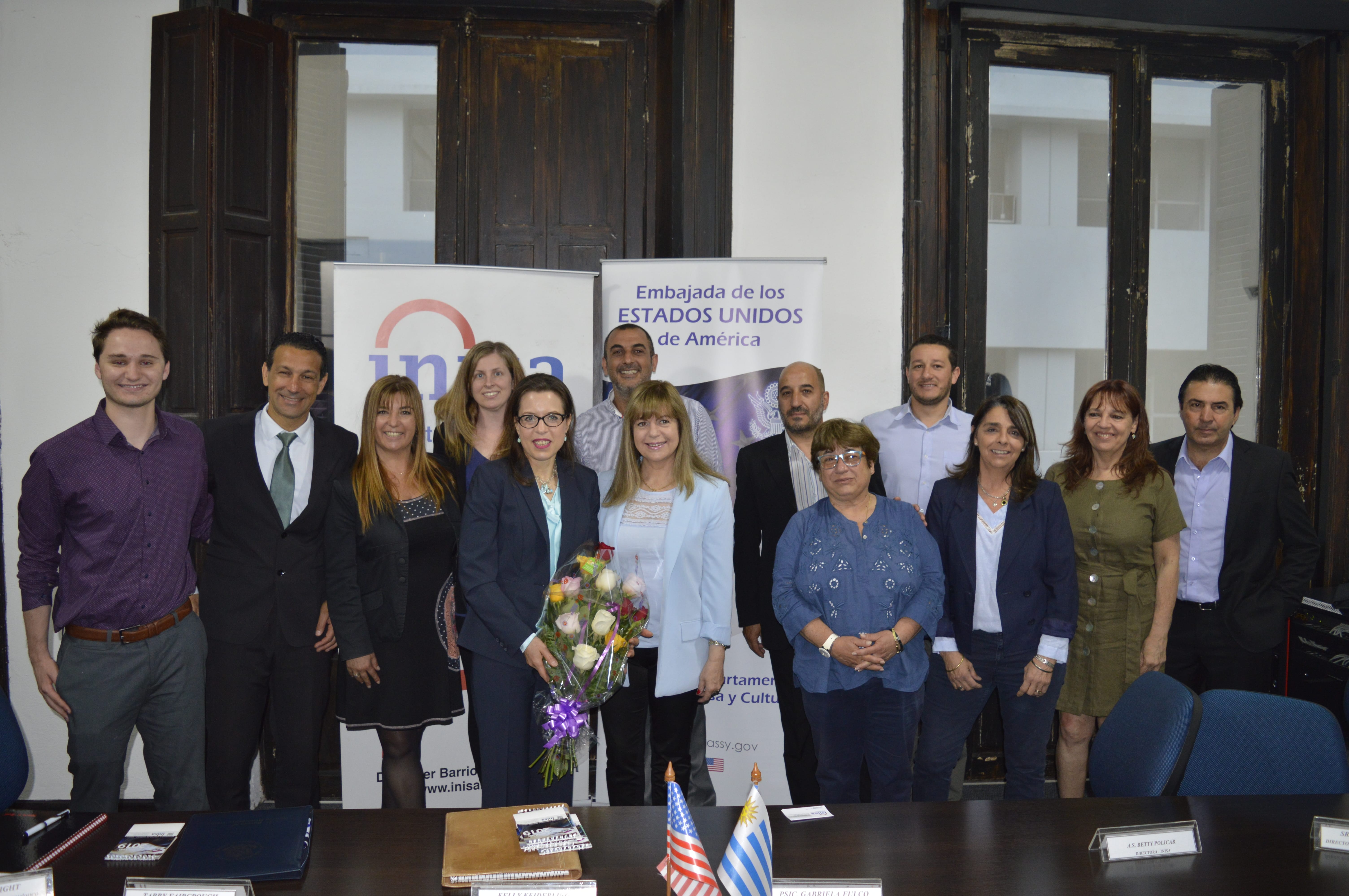 Foto de funcionarios de la embajada de Estados Unidos entregando ramo de flores a la directora y a la presidente de Inisa